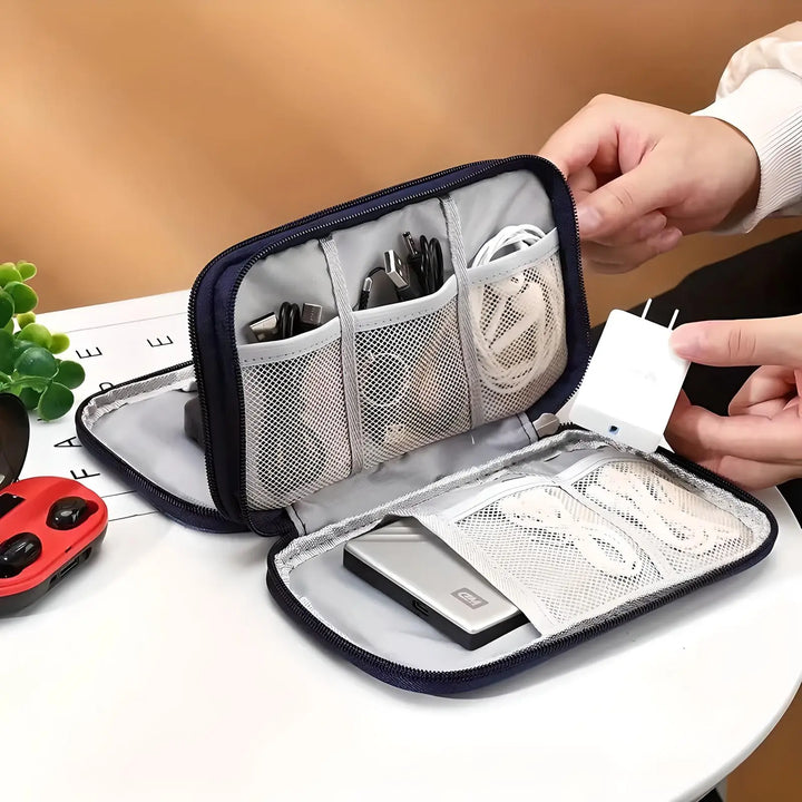 Elegancki czarny organizer podróżny, chroniący akcesoria elektroniczne i kable przed uszkodzeniem i zagubieniem.