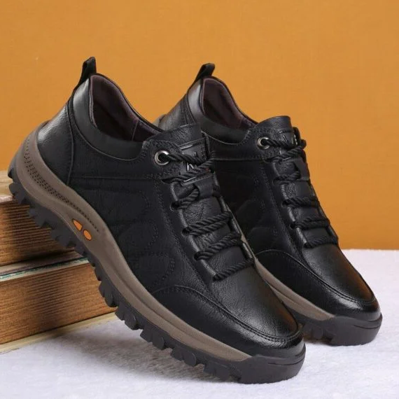 Męskie czarne buty casualowe na tle książek prezentujące stabilną budowę
