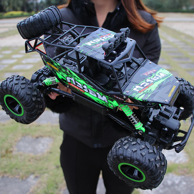Zielony zdalnie sterowany monster truck trzymany w rękach