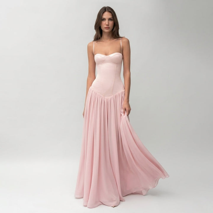Modelka prezentująca różową elegancką sukienkę maxi z gorsetem od przodu