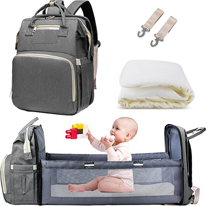 Mama z dzieckiem na spacerze, korzystająca z plecaka na pieluchy z funkcją rozkładanej kołyski turystycznej.