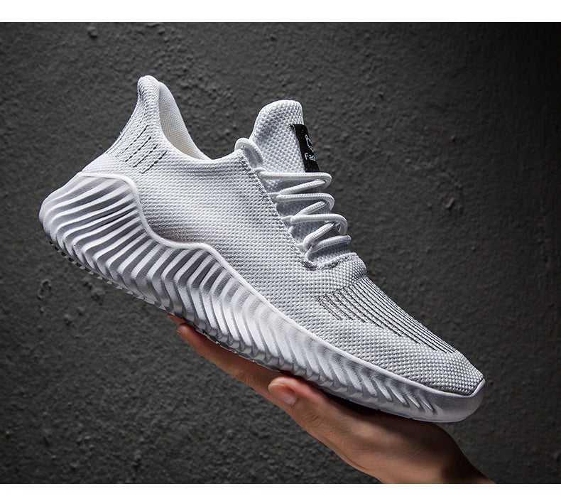 Białe męskie sneakersy sportowe z oddychającą siateczką trzymane w dłoni