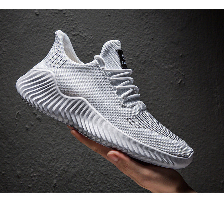 Białe męskie sneakersy sportowe z oddychającą siateczką trzymane w dłoni