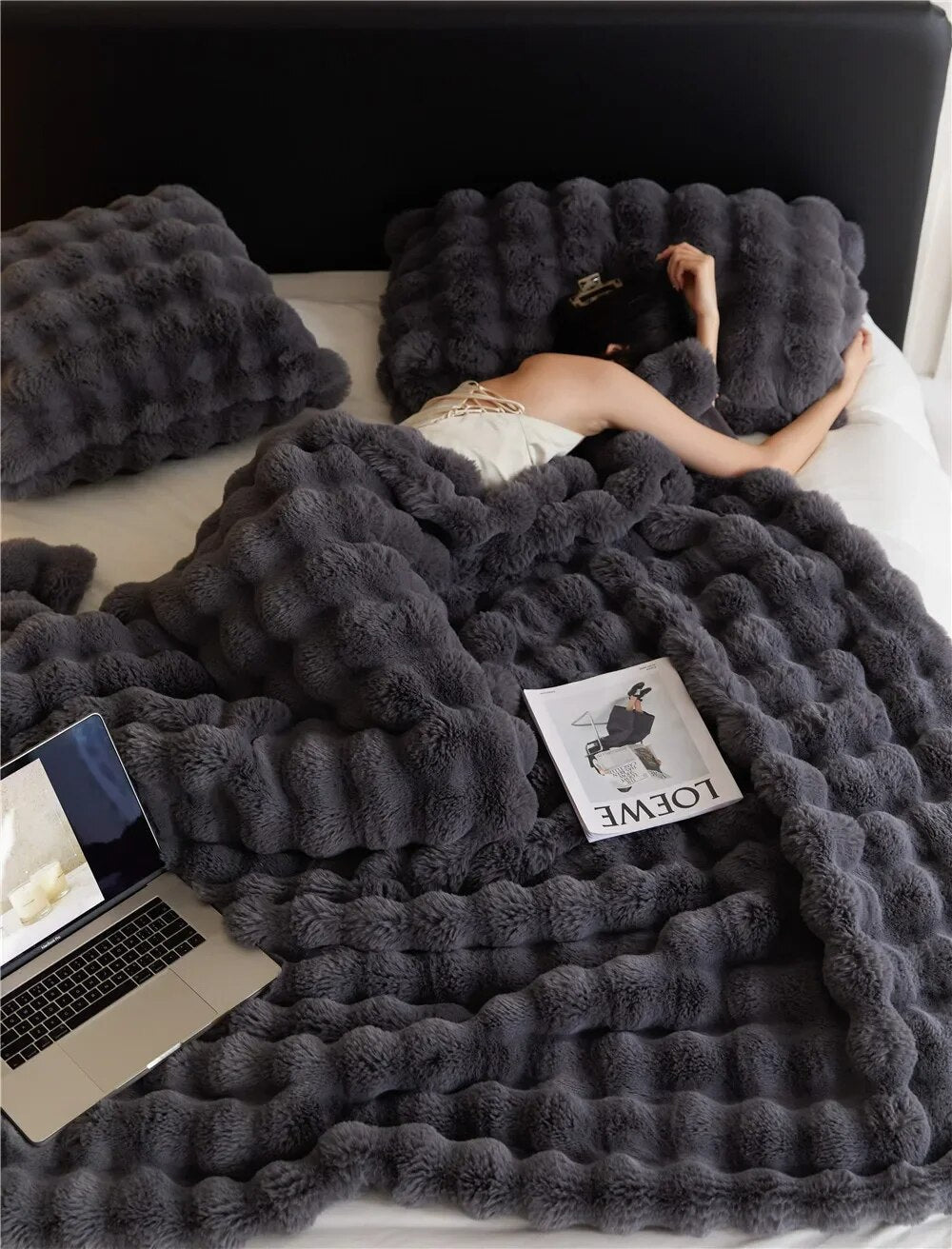 Miękki, wełniany koc WarmWool o puszystej teksturze, doskonały do przytulnego wnętrza salonu lub sypialni.