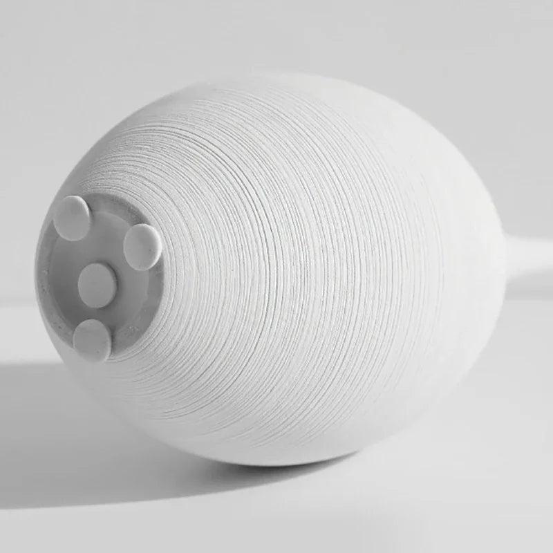 Minimalistyczny biały wazon ceramiczny, rękodzieło, spokojny akcent dla domowej aranżacji.