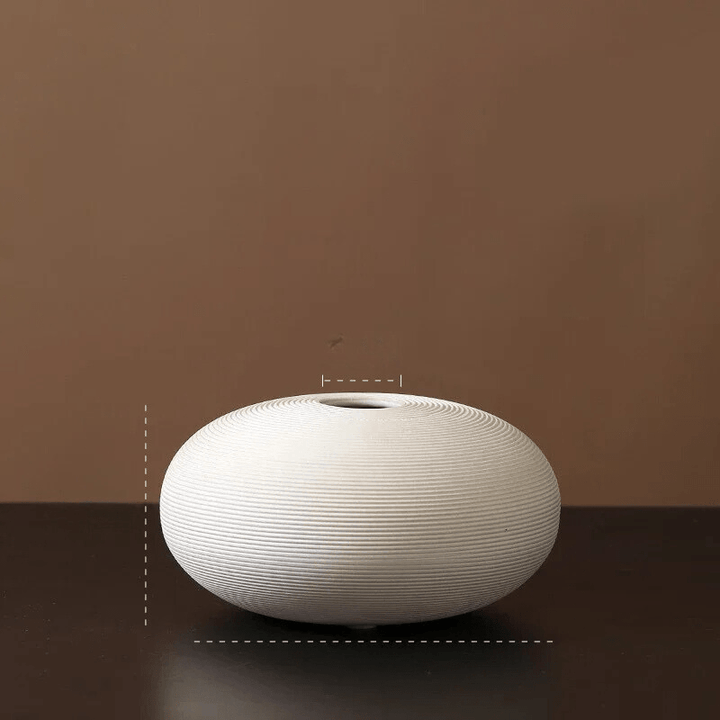 Wazon ceramiczny w aranżacji z kwiatami, biały, minimalistyczny, podkreślający styl domu.
