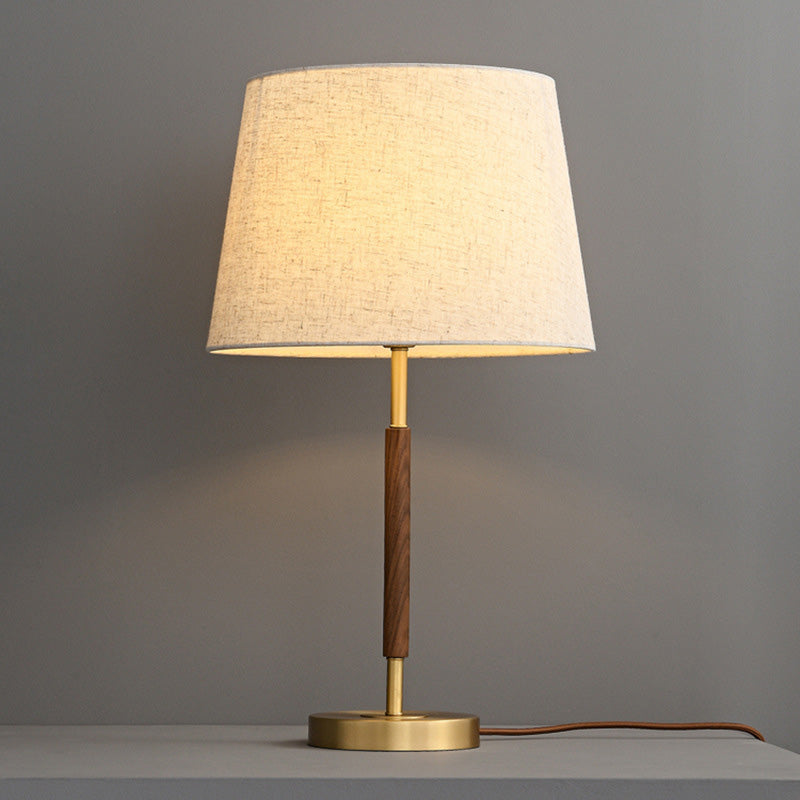 Antyczna mosiężna lampka nocna w kształcie walca. Retro dekoracja i funkcjonalne oświetlenie do sypialni.