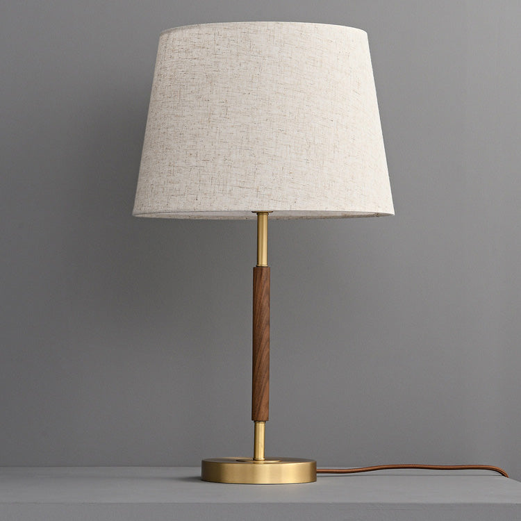 Designerska lampka nocna retro z mosiądzu. Cylindryczny kształt, idealny do stworzenia przytulnej atmosfery.
