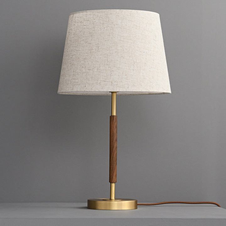 Designerska lampka nocna retro z mosiądzu. Cylindryczny kształt, idealny do stworzenia przytulnej atmosfery.