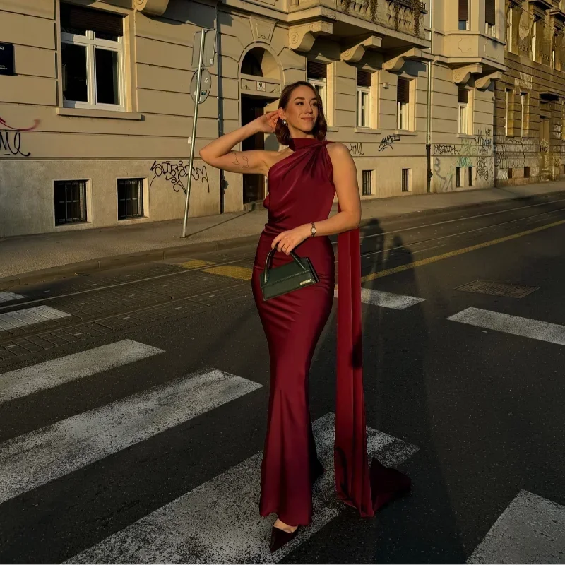 Kobieta w bordowej sukience wieczorowej maxi z dekoltem halter na ulicy