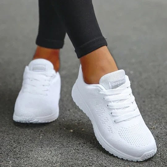 Zbliżenie na białe wygodne sneakersy damskie w plenerze