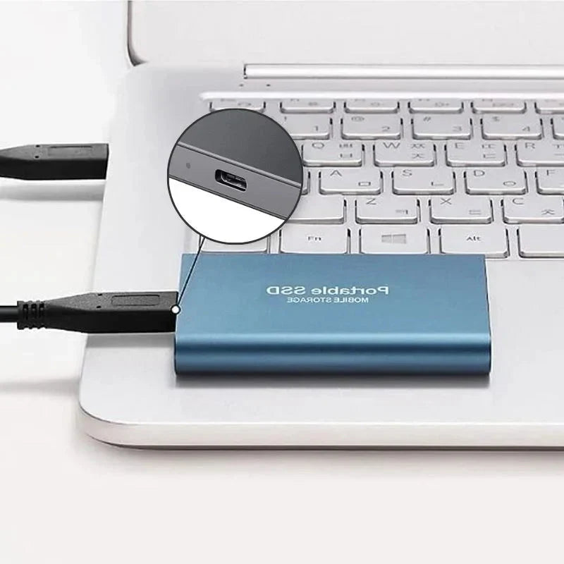 Niebieski przenośny dysk SSD podłączony do laptopa przez kabel USB-C