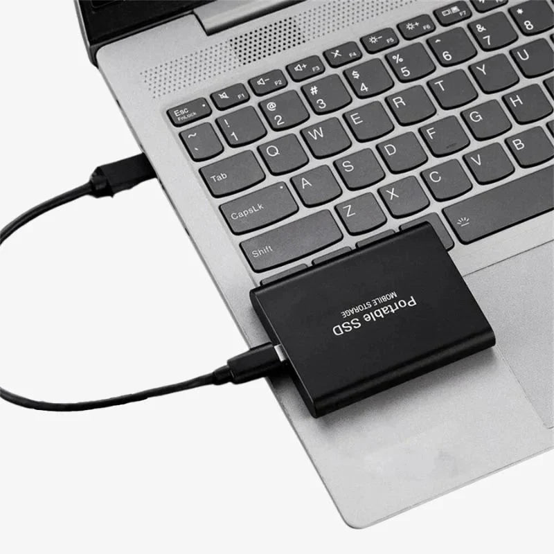 Czarny przenośny dysk SSD podłączony do nowoczesnego laptopa