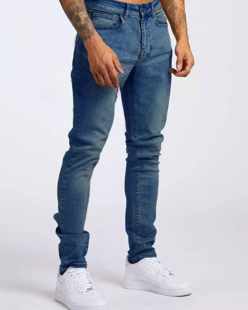 Mężczyzna w niebieskich jeansach slim fit i białych sneakersach