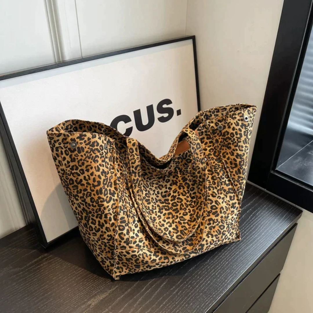 Elegancka czarna torba shopper w panterkę prezentowana na blacie