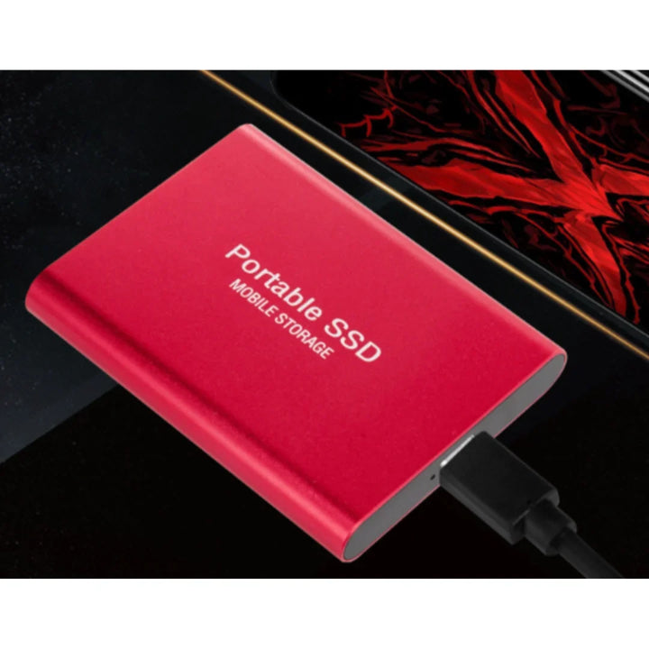 Czerwony przenośny dysk SSD USB-C leżący obok urządzenia mobilnego