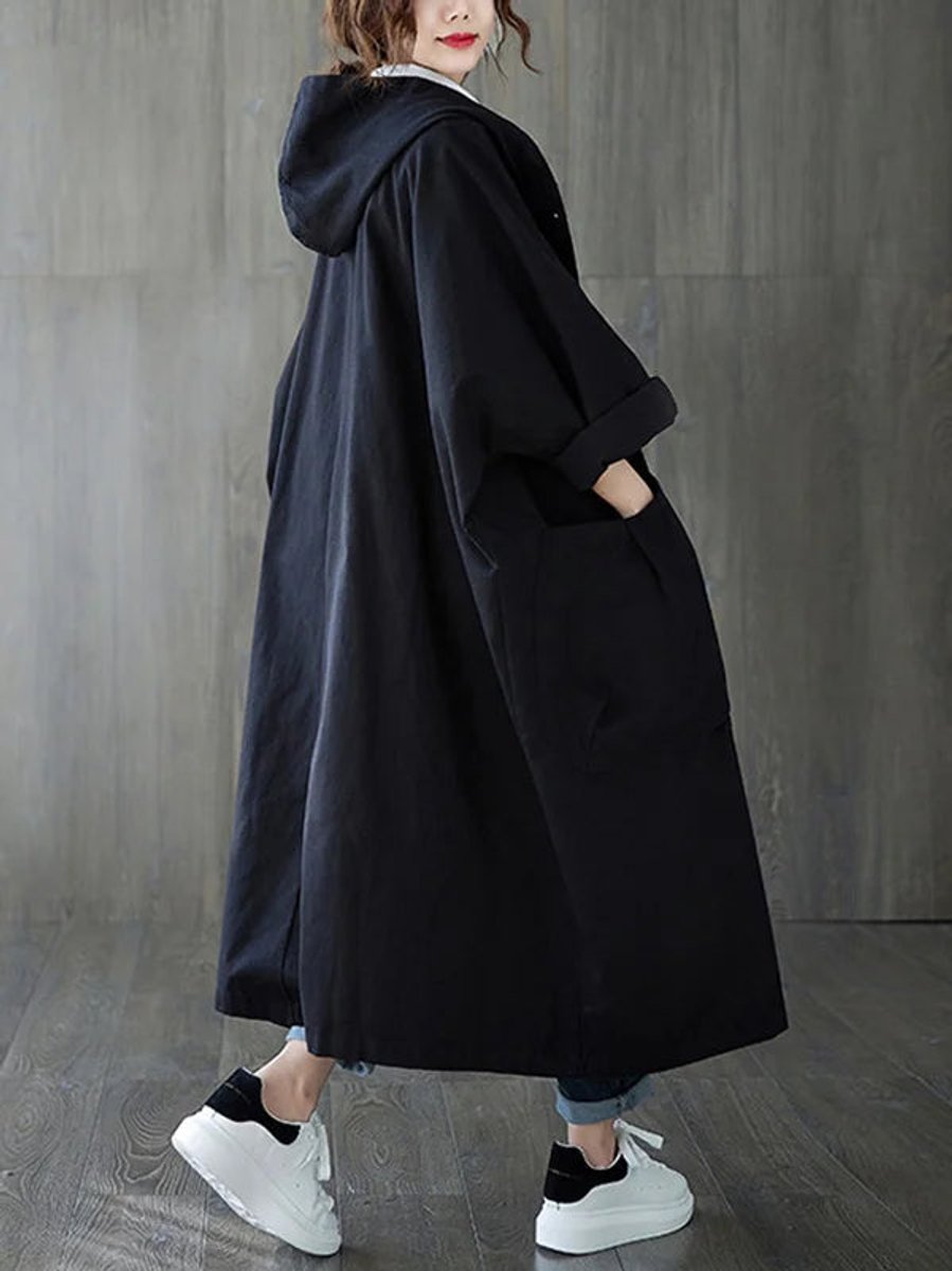Stylowy czarny trencz damski oversize z kapturem widoczny od tyłu