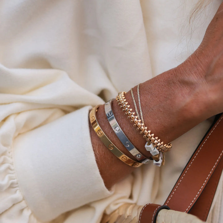 Złota bransoletka bangle ze śrubami, elegancka i minimalistyczna biżuteria uniseksowa, idealna na prezent.