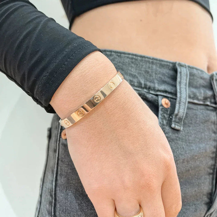 Różowozłota bransoletka bangle, minimalistyczny design ze śrubami, elegancka biżuteria uniseksowa.