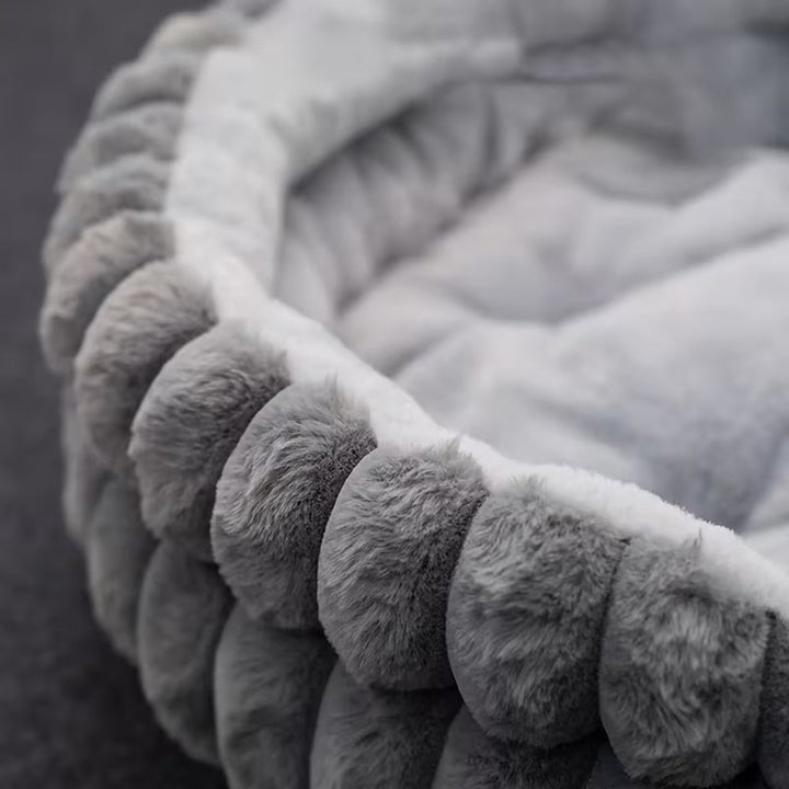 Uspokajające legowisko dla kota typu donut. Pluszowe posłanie z miękkim wypełnieniem i wysokimi brzegami dla relaksu.