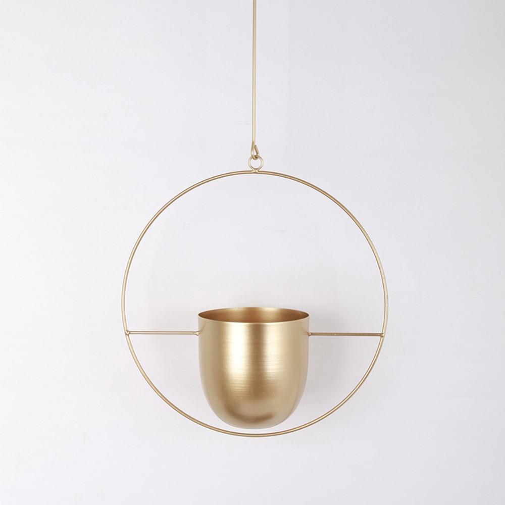 Stylowy wiszący metalowy kwietnik. Nowoczesny wieszak na rośliny o minimalistycznym designie. Dom i ogród.