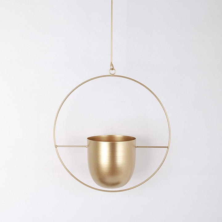 Stylowy wiszący metalowy kwietnik. Nowoczesny wieszak na rośliny o minimalistycznym designie. Dom i ogród.