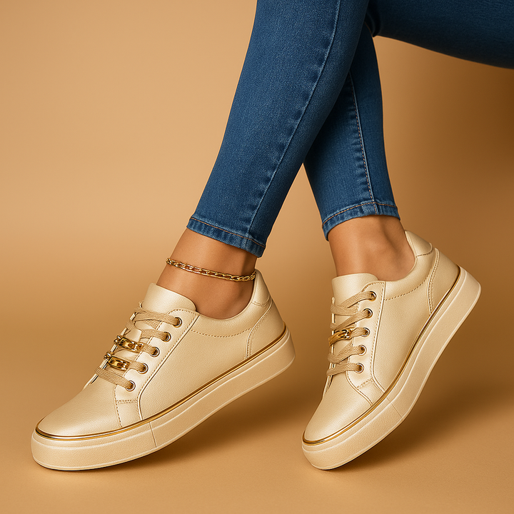 Stylowe złote sneakersy damskie prezentowane na nodze z jeansami