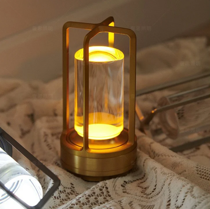 Lampa stołowa LED złota, dotykowa, bezprzewodowa, tworząca ciepłą atmosferę w wieczornym wnętrzu.