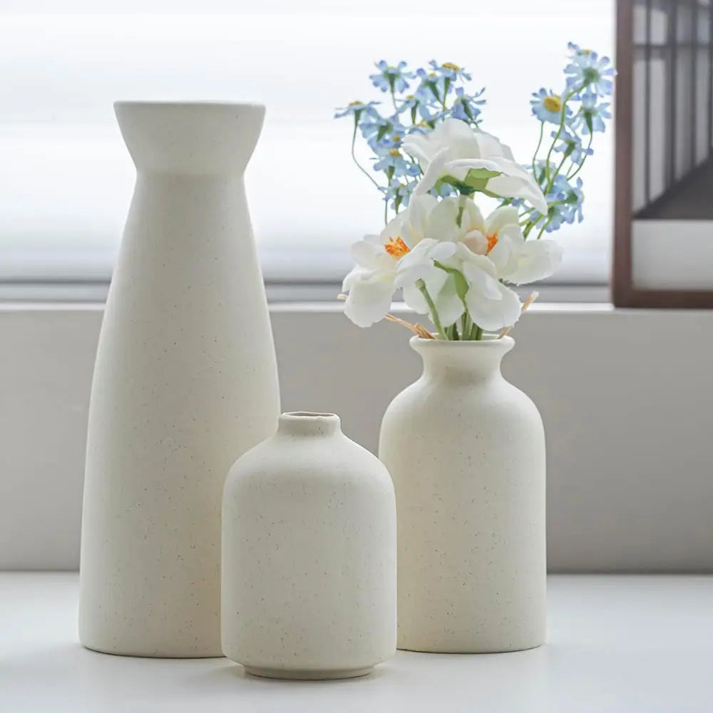 Nowoczesne, białe wazony ceramiczne, idealne jako minimalistyczna dekoracja do salonu lub sypialni.