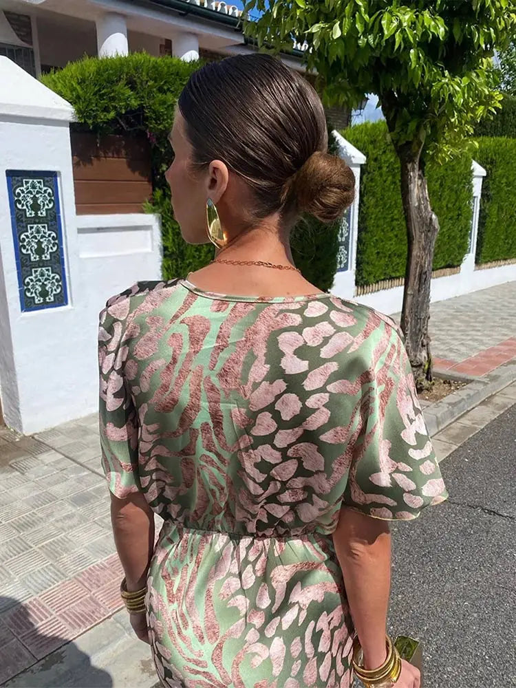 Elegancka damska sukienka midi zielona. Kopertowy dekolt V i bufiaste rękawy dodają stylu. Wiosenna sukienka.