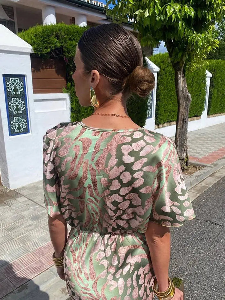 Elegancka damska sukienka midi zielona. Kopertowy dekolt V i bufiaste rękawy dodają stylu. Wiosenna sukienka.